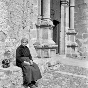 Señora sentada, junto a la portada de la Iglesia de San Mateo.