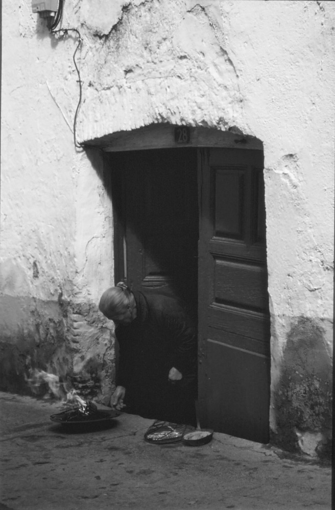 Mujer preparando un brasero de picón