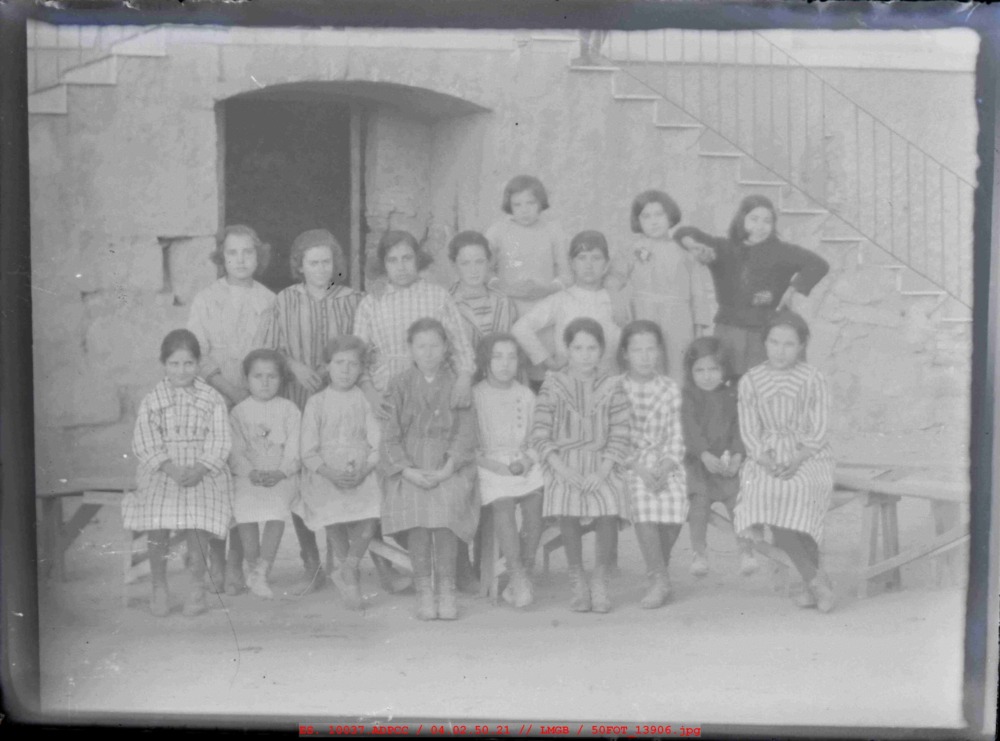 17 niñas delante de las escaleras del colegio