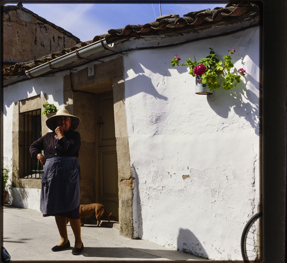 Anciana ante una casa