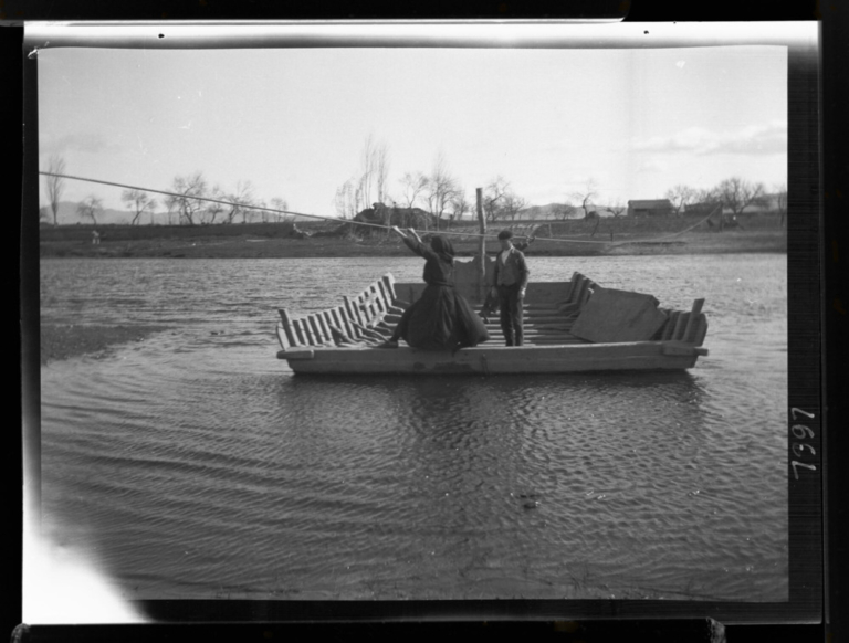 Barquera moviendo la barca por el cable en el río Jerte
