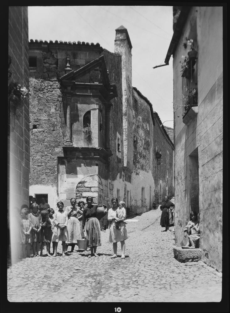 Calle empedrada con balcón en la esquina del edificio