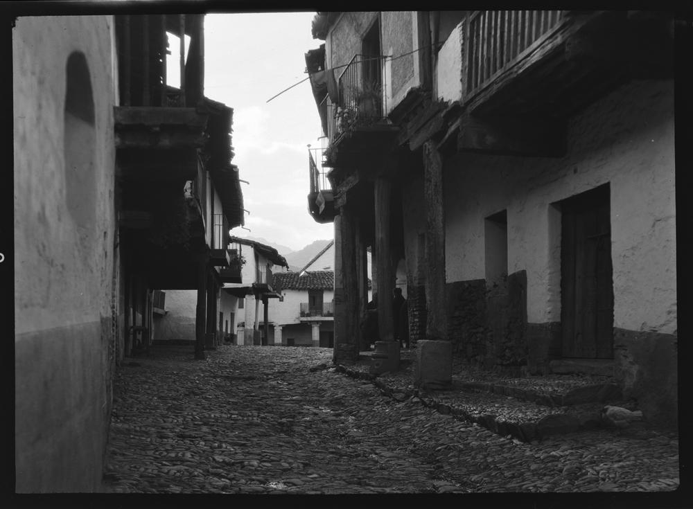 Calle empedrada con casas típicas sujetas sobre pilares