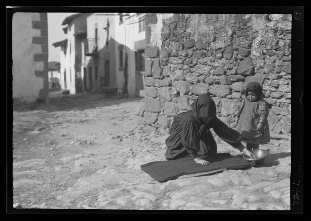 Costurera humedeciendo una falda en la calle para plisarla