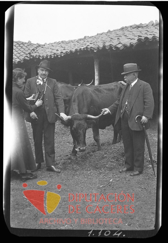 Dos hombres posan con una res