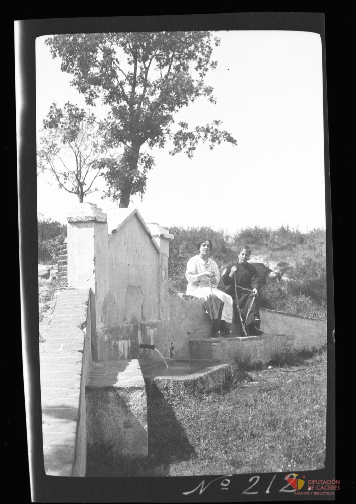 Dos mujeres sentadas junto a una fuente