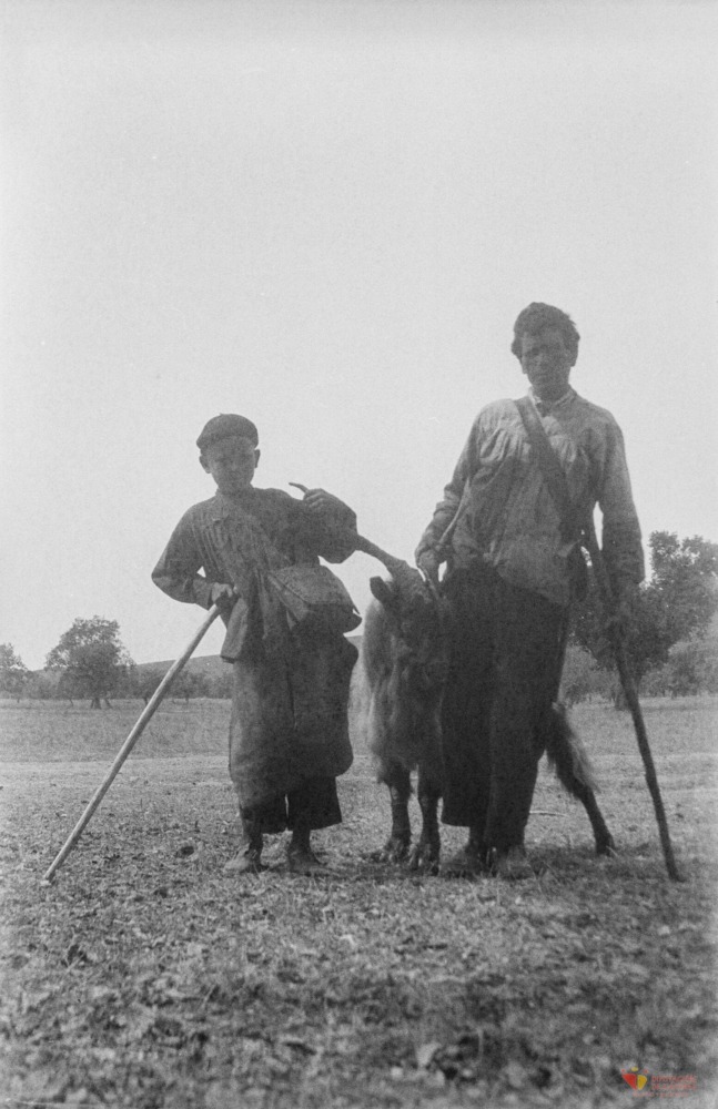 Dos pastores junto a un macho cabrío