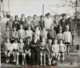 Fotografía de grupo de niños de varias edades delante de un muro, 1930