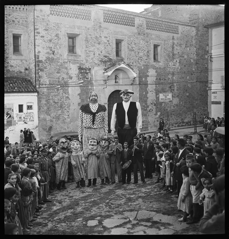 Grupo de niños en torno a dos gigantes, cuatro cabezudos · Juan Miguel Pando Barrero, 1951