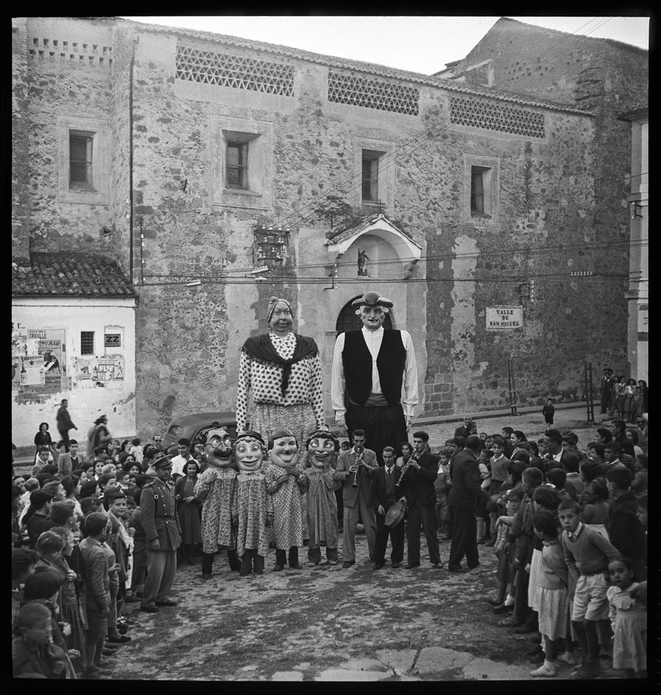Grupo de niños en torno a dos gigantes, cuatro cabezudos · Juan Miguel Pando Barrero, 1951