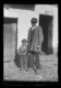 Hombre con gorro negro de piel de oveja y niño · Ruth Matilda Anderson, 1928