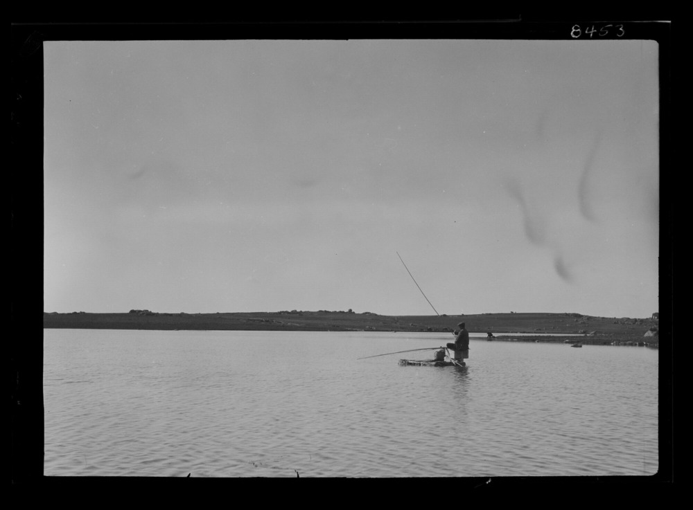 Hombre pescando en una charca grande