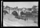 Hombres vendiendo cerdos en la margen izquierda. Vista del puente de Trujillo, la catedral y el palacio episcopal · Ruth Matilda Anderson, 1928