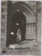 Mujer con trajes típico junto a la puerta de la iglesia · Francisco Olivenza, 1952