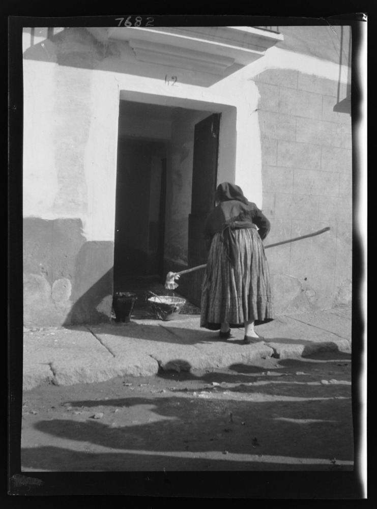 Mujer encalando su casa