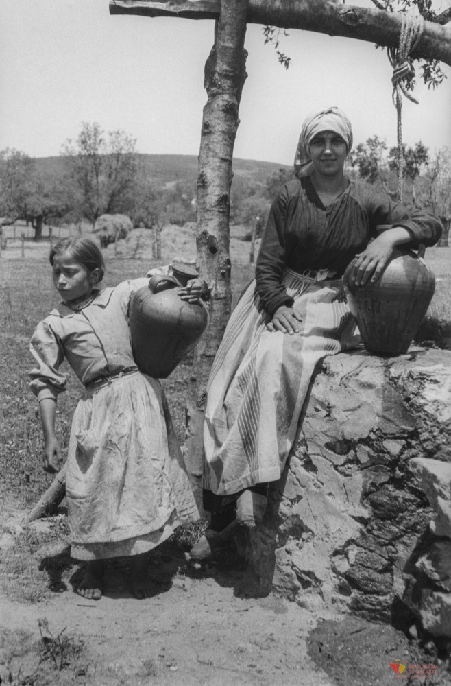 Mujeres con cántaros cerca de un pozo