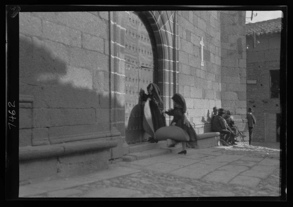 Mujeres entrando a misa con esterillas de esparto para arrodillarse