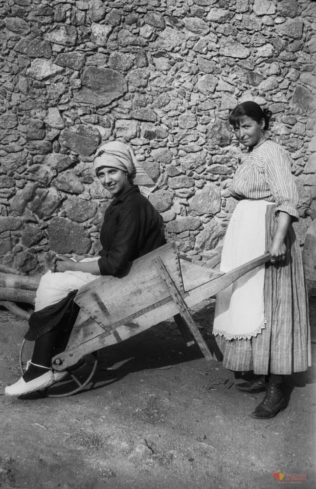 Mujeres posan con una carretilla