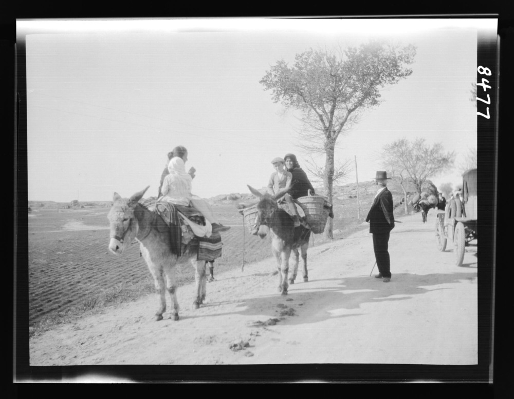 Mujeres y niños montados en burro
