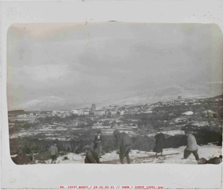 Niños y sacerdote jugando con la nieve