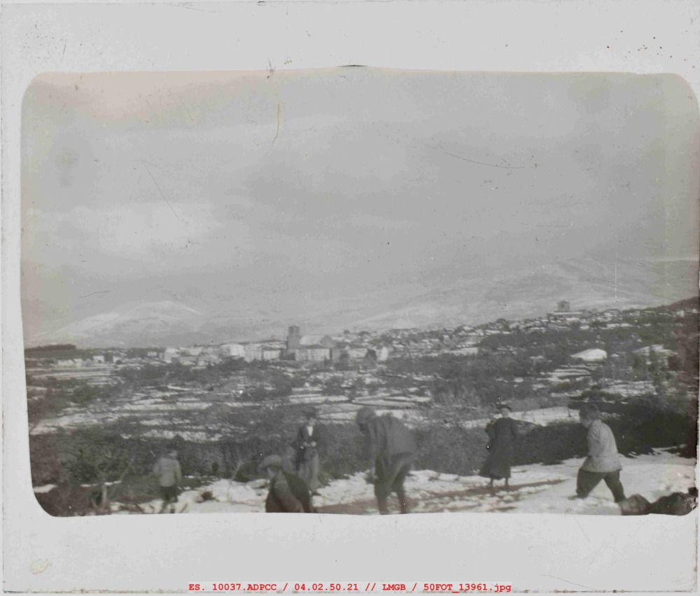 Niños y sacerdote jugando con la nieve