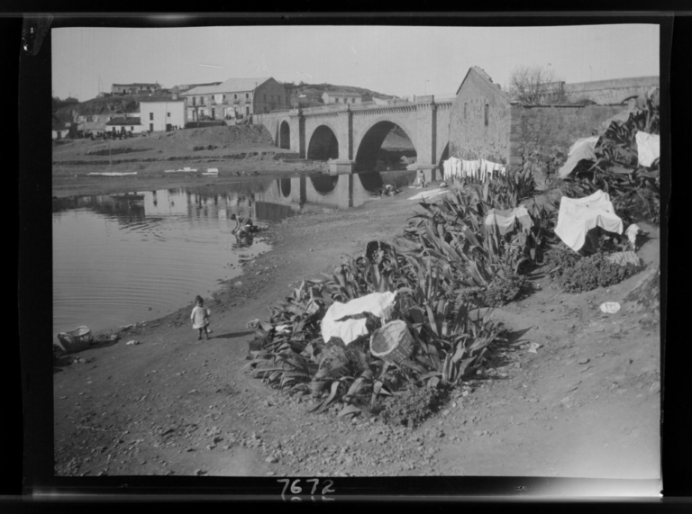 Tres mujeres lavando ropa en la margen derecha del río