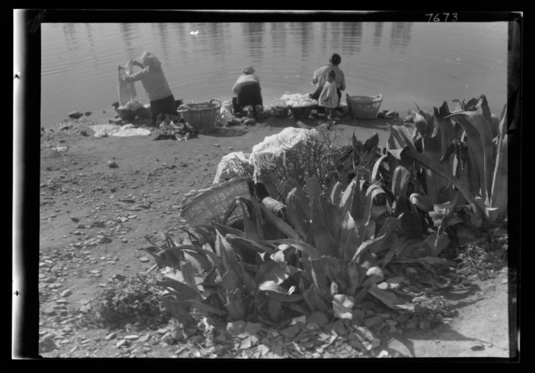 Tres mujeres lavando ropa en la margen derecha del río