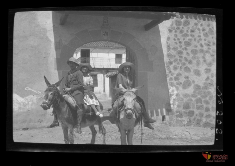 Una pareja y una mujer montando en burro