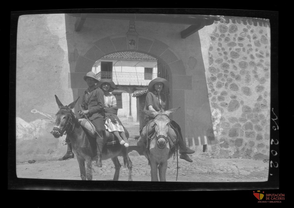 Una pareja y una mujer montando en burro